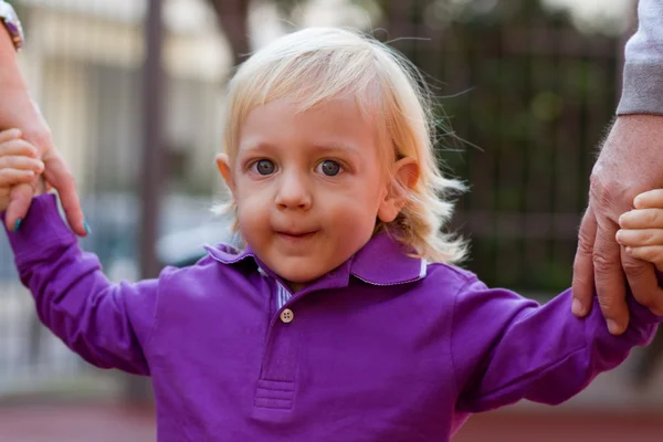 Liten blond pojke och hans familj utomhus — Stockfoto