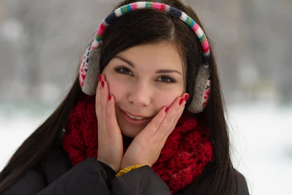 Девушка в затычках для ушей зимой — стоковое фото