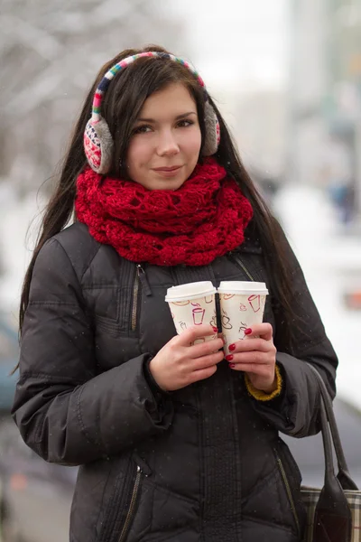 Söt tjej i öronproppar med kaffekopp — Stockfoto