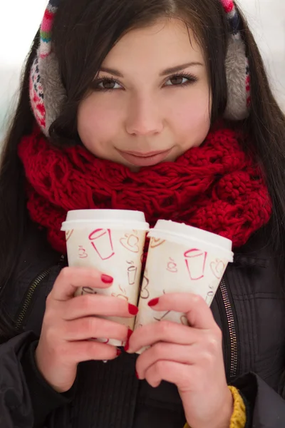 Menina bonito em tampões de ouvido com xícara de café — Fotografia de Stock