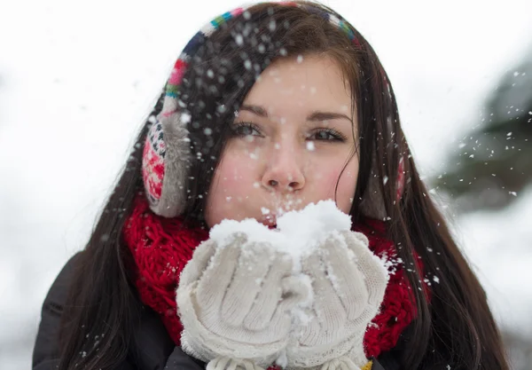 Flicka blåser fluffiga snöflingor — Stockfoto