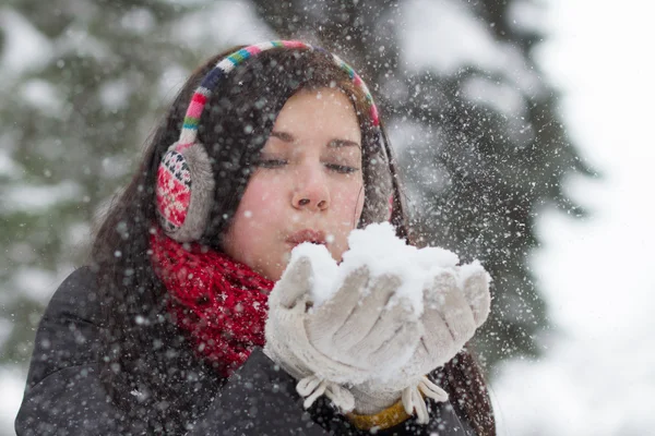 Menina soprando flocos de neve macios — Fotografia de Stock