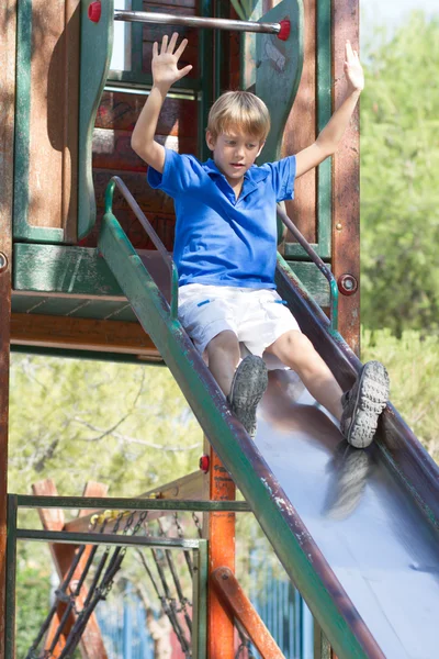 Young boy on a slide in the park — Stock Photo, Image