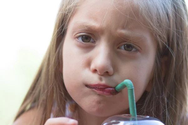 Funny little girl drinks milkshake — Stock Photo, Image