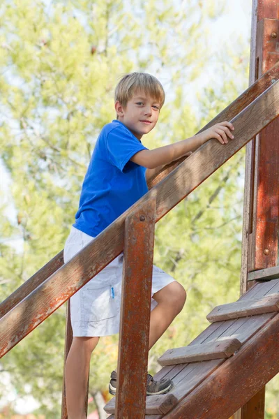 Junge klettert auf Leiter auf Spielplatz — Stockfoto