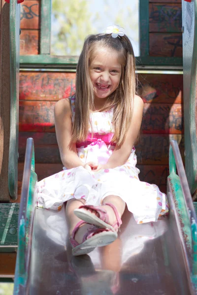 Little girl on a slide in the park — Stock Photo, Image