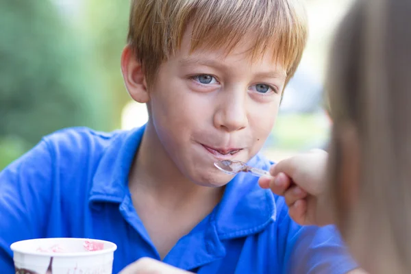 Pikkupoika syö jäätelöä. — kuvapankkivalokuva