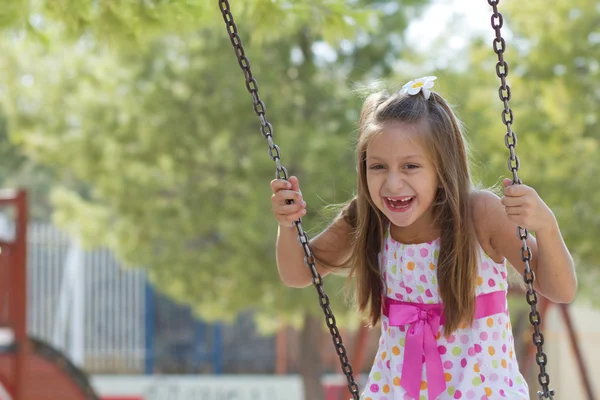 Little girl swinging in the park — Stock Photo, Image