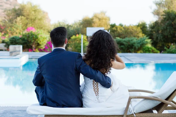 Junge Frau und Mann sitzen am Pool — Stockfoto
