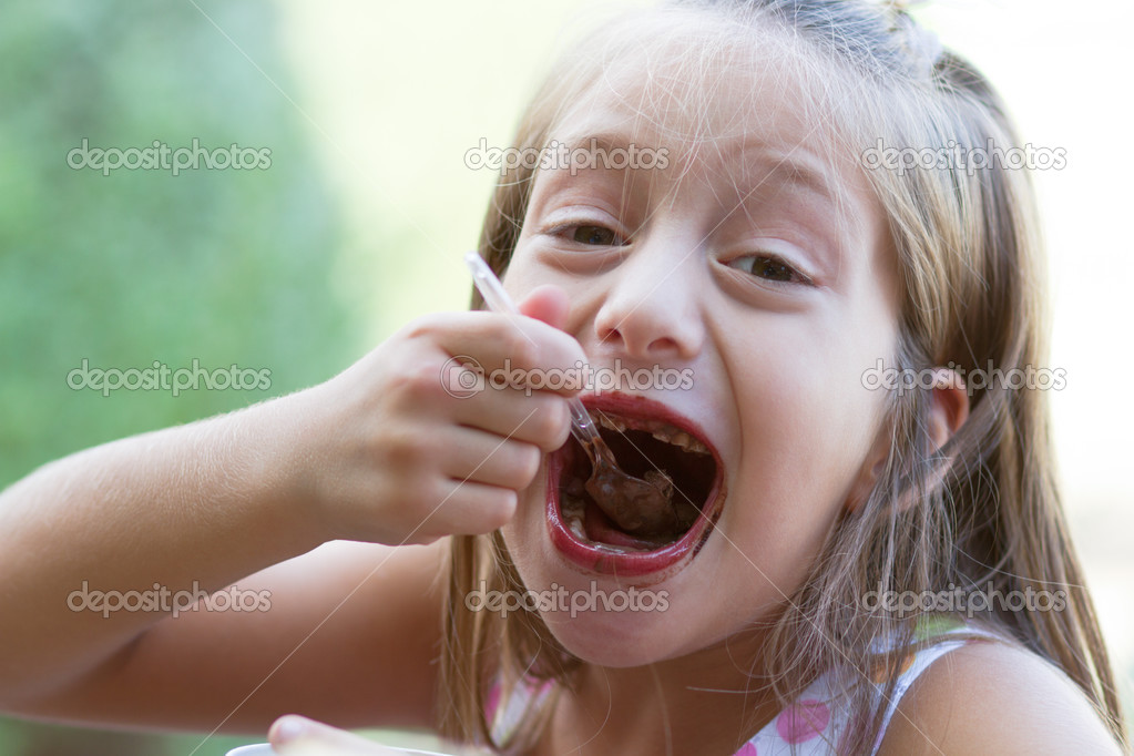 Funny toothless little girl eats ice-cream