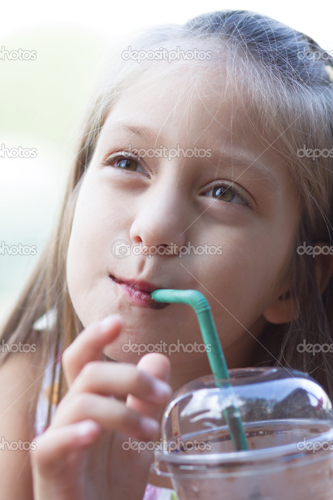 Funny little girl drinks milkshake