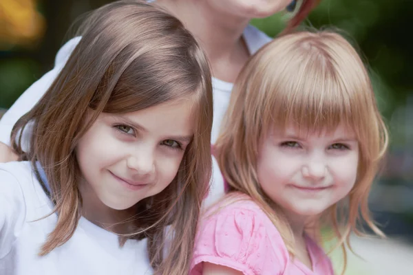 Schattige kleine meisjes met hun moeder buitenshuis — Stockfoto