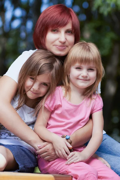 Schattige kleine meisjes met hun moeder buitenshuis — Stockfoto