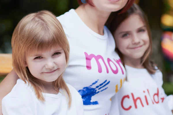 Schattige kleine meisjes met hun moeder buitenshuis — Stockfoto