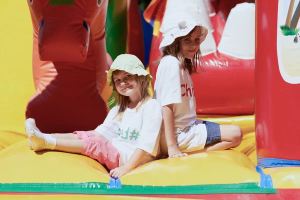 Cute little sisters in a jumping castle — Stock Photo, Image