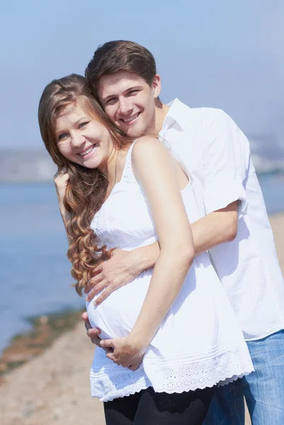 Chica embarazada feliz y su marido cariñoso — Foto de Stock