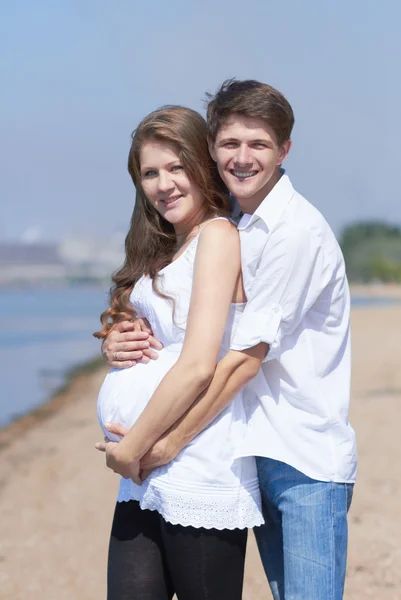 Chica embarazada feliz y su marido cariñoso —  Fotos de Stock