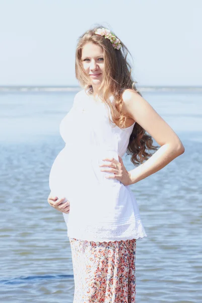 Gelukkig zwangere meisje op het strand — Stockfoto