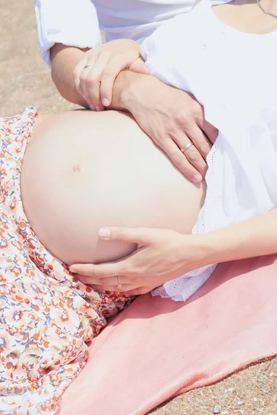 Familia joven embarazada en la playa — Foto de Stock