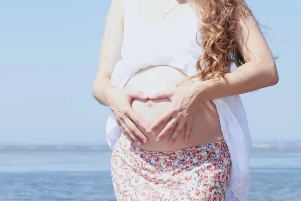 Glad gravid flicka på stranden — Stockfoto