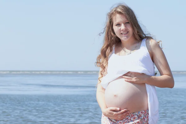 Chica embarazada feliz en la playa — Foto de Stock