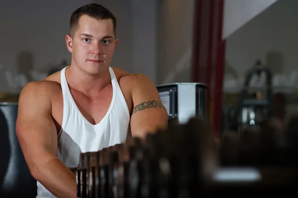 Pumped young man with tattoo in gym — Stock Photo, Image