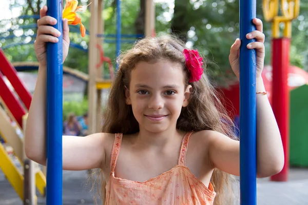 Kleines Mädchen schwingt auf dem Spielplatz — Stockfoto