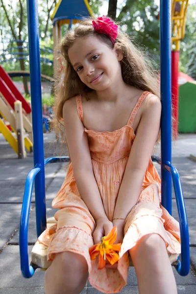 Kleines Mädchen schwingt auf dem Spielplatz — Stockfoto