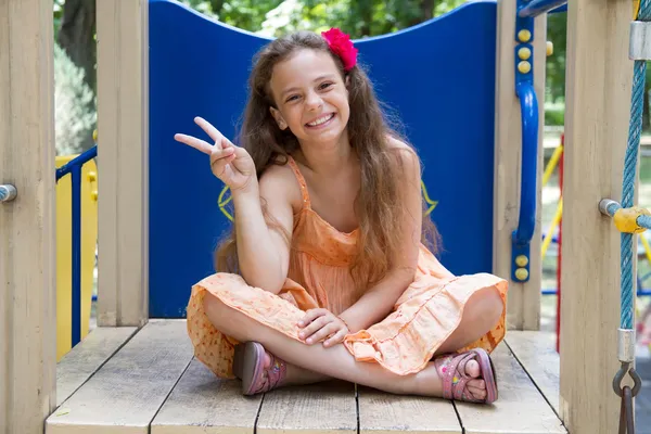 Glückliches kleines Mädchen zeigt Siegesgeste — Stockfoto