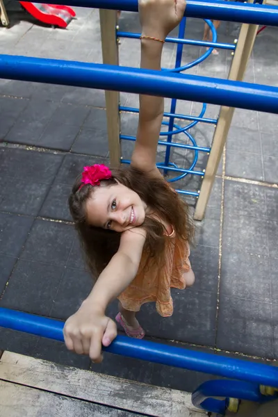 Little girl hanging on the playground — Stock Photo, Image