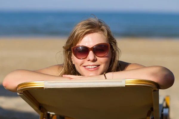 Blond meisje om te zonnebaden op een lounge — Stockfoto