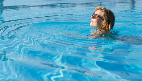 Chica rubia nadando en una piscina —  Fotos de Stock