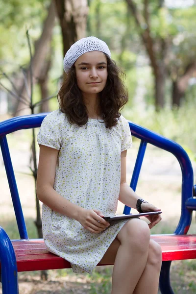 Tienermeisje met trendy tablet pc in park — Stockfoto