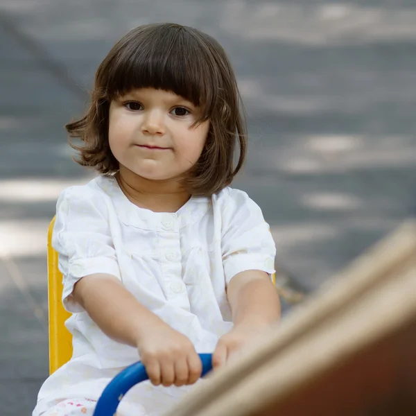 Linda niña en columpio en el patio —  Fotos de Stock