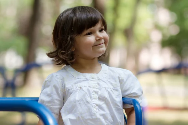 Petite fille sur un manège dans le parc — Photo