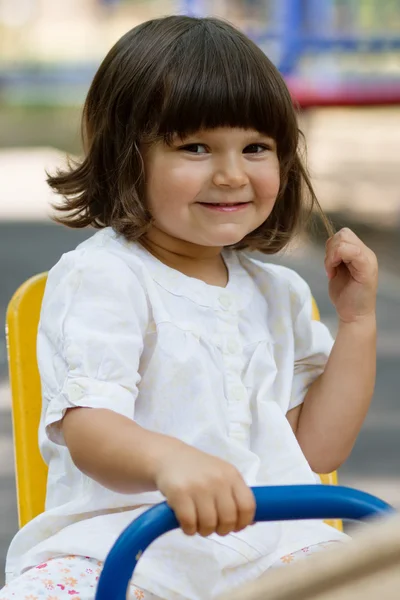 Mignonne petite fille sur swing dans la cour de récréation — Photo