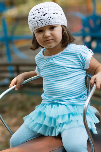 Petite fille chevauchant un carrousel dans un parc d'attractions — Photo