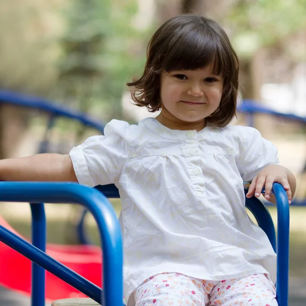 Petite fille sur un manège dans le parc — Photo