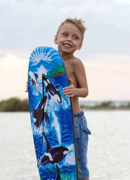 Щасливий маленький хлопчик з дошкою для серфінгу — стокове фото