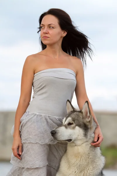 Giovane donna con cane malamuto alaskan — Foto Stock