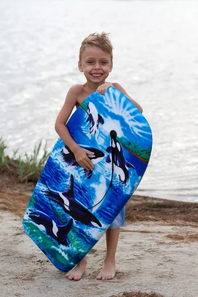 Joyeux petit garçon avec planche de surf — Photo