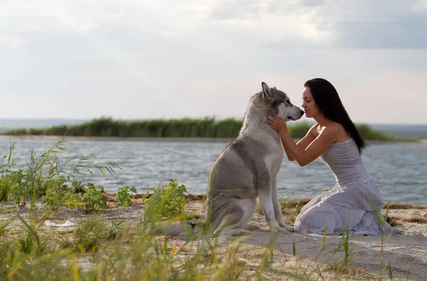 Giovane donna con cane malamuto alaskan — Foto Stock