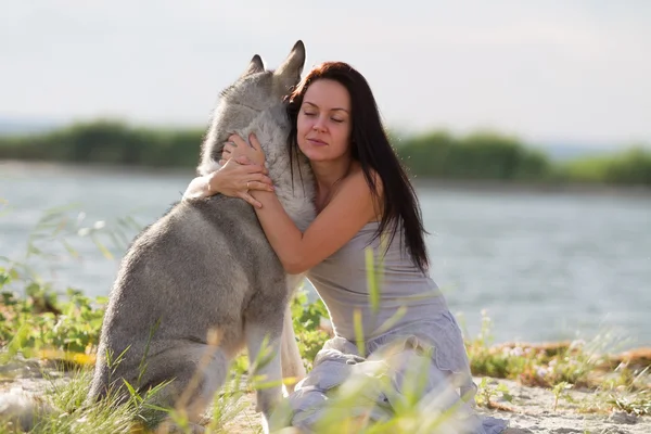 Młoda kobieta z psem alaskan malamute — Zdjęcie stockowe