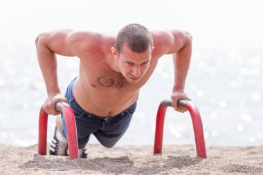 genç adam sahilde şınav mı