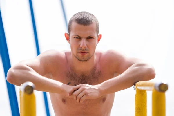 Joven serio haciendo ejercicio en bares — Foto de Stock