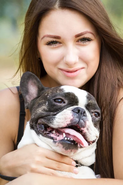 Sorrindo menina segurando um bulldog — Fotografia de Stock