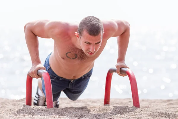 Joven hacer las flexiones en la playa — Foto de Stock