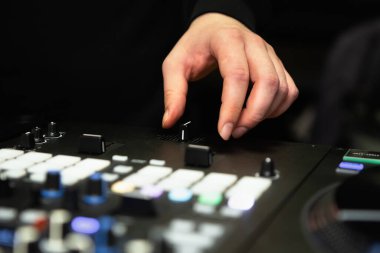 DJ 'in elleri ses mikserinde müziği karıştırıyor. Hip hop disk jokeyi plakları çizer ve gece kulübünde müzik parçalarını sahnede profesyonel ses ekipmanıyla karıştırır.