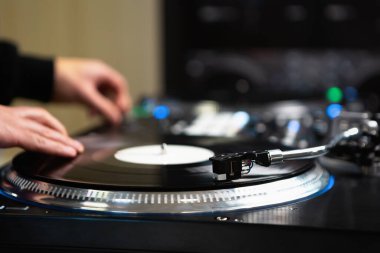 DJ sehpaya plak çiziyor. Profesyonel hip hop disk jokeyi partideki müzik parçalarını karıştırıyor
