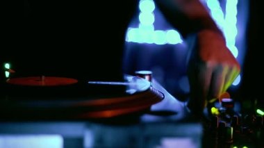 Techno dj, gece kulübünde, analog turntable çalarken retro vinil plaklar eşliğinde müzik setini çalıyor. Müzik parçalarını neon ışıklarda karıştıran profesyonel disk jokeyinin video klibi 